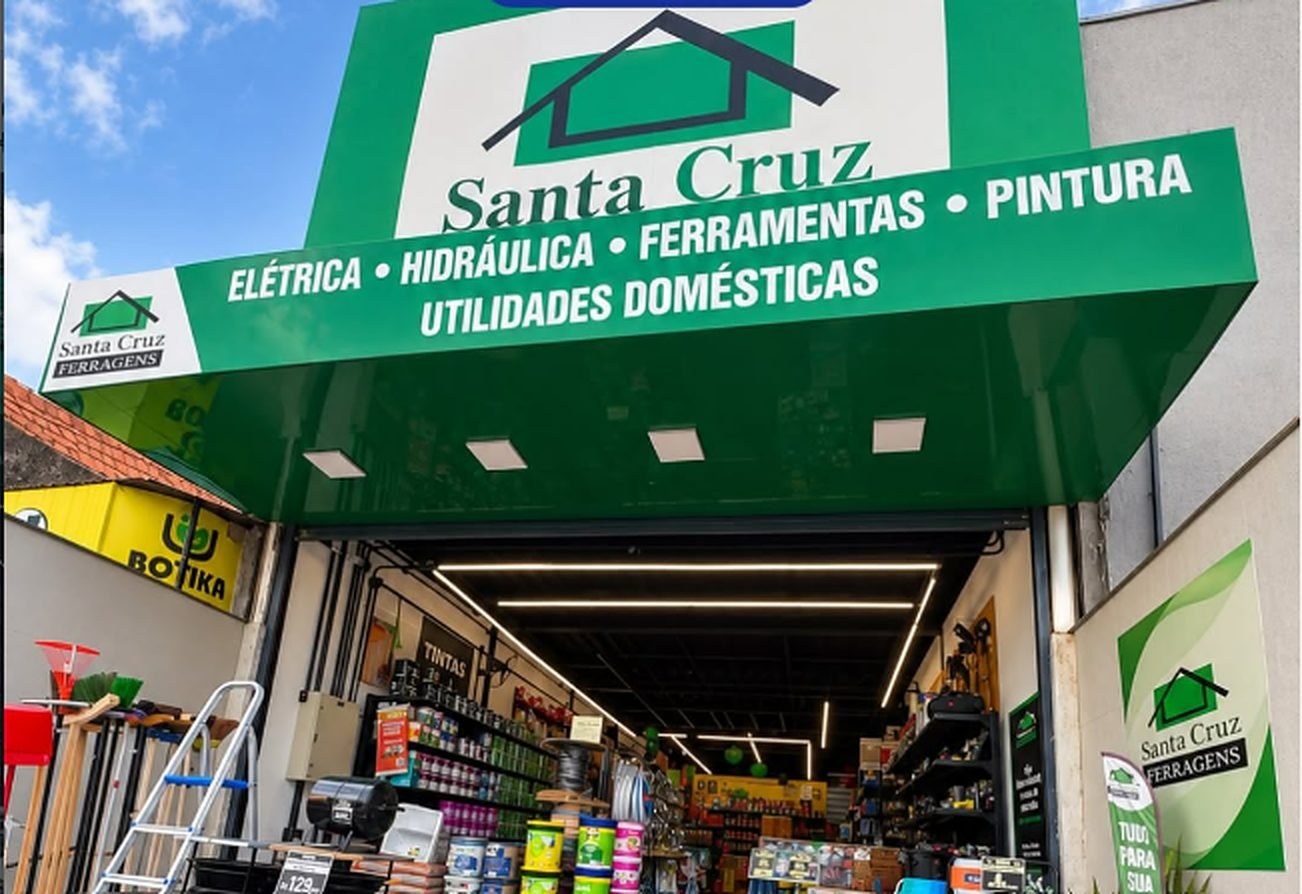 Fachada da Santa Cruz Ferragens com letreiro verde: elétrica, hidráulica, ferramentas, pintura e utilidades domésticas
